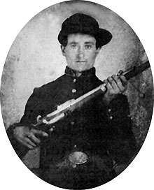Black and white photograph of Private Hezekiah Blevens of Company C wearing his Civil War uniform and holding a musket